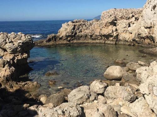 a small pool of water on a rocky beach at Terrazza Sul Mare in Terme Vigliatore