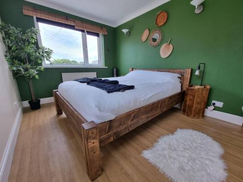 a bedroom with a wooden bed in a green wall at Seaview Sands Beach Apartment in Southbourne