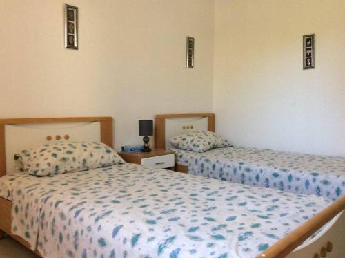 una camera con due letti e un comodino di Villa Kenza a Nabeul