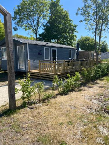 a tiny house with a porch and a deck at 4 persoons chalet HZ 21 in Lauwersoog