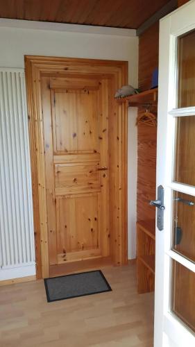 a wooden door in a room with a wooden floor at Ruhiges Ferienhaus In Goting Mit Grill, Terrasse Und Garten in Nieblum