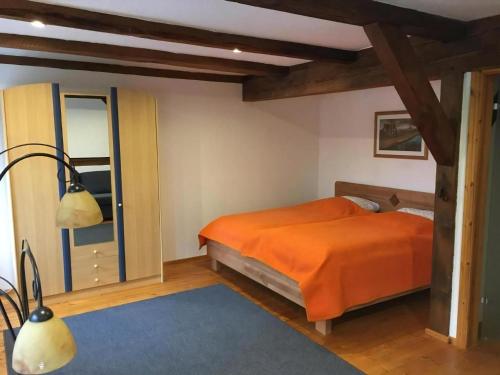 a bedroom with an orange bed and a lamp at Ferienwohnung Kastanienblick in Ziethen