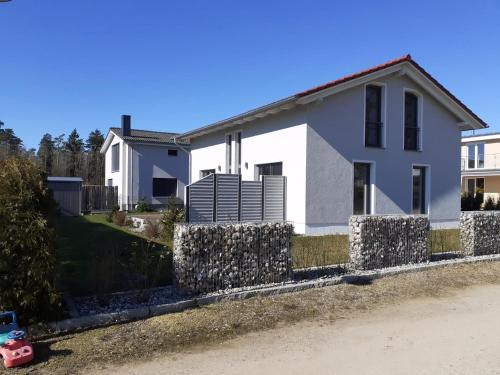 una casa bianca con un muro di pietra di Ferienhaus Vanessa Für 8 Personen a Dümmer