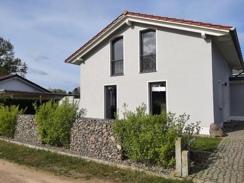 una casa bianca con un muro di pietra di Ferienhaus Vanessa Für 8 Personen a Dümmer