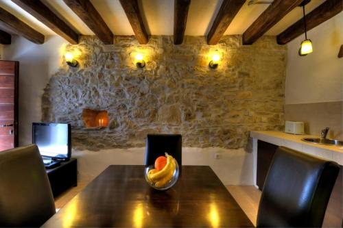 a wooden table with a bowl of fruit on it at Stone House Kotli in Kotli