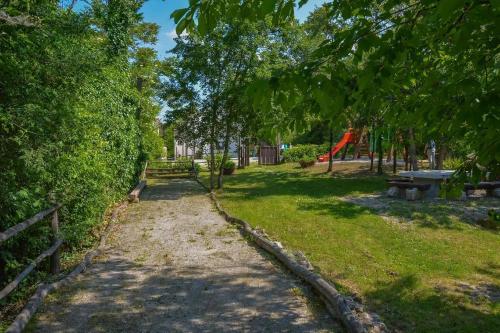 a dirt path in a park with a playground at Stone House Kotli in Kotli