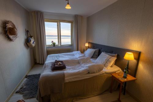 a bedroom with a large bed with a window at Bungenäs Badhotell in Fårösund