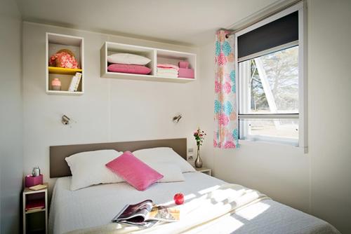 a bedroom with a bed with pink pillows and a window at Ferienhaus In Hohenlychen Mit Grill, Loggia 2 in Lychen