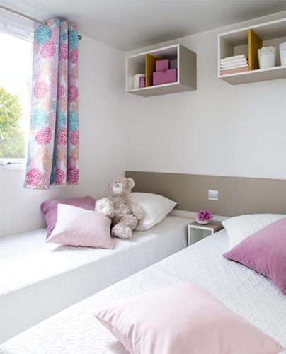 a teddy bear sitting on two beds in a bedroom at Ferienhaus In Hohenlychen Mit Grill, Loggia 2 in Lychen