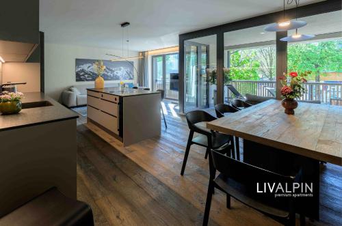 a kitchen and living room with a table and chairs at LIVALPIN Suite in Garmisch-Partenkirchen