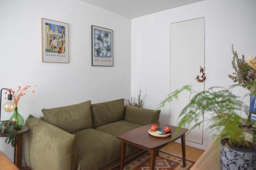 un salon avec un canapé et une table dans l'établissement Bright 1 bedroom apartment - near park, à Paris