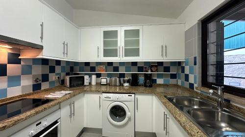 a kitchen with a washing machine and a sink at Golfinho - Private Pool - 10 Guests - Albufeira in Albufeira