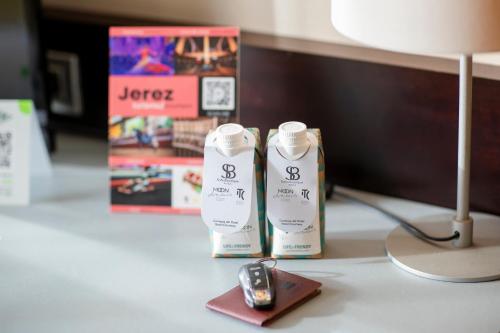 a desk with two bottles of sunscreen and a lamp at Itaca Jerez by Soho Boutique in Jerez de la Frontera