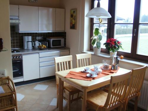 a kitchen with a wooden table with chairs and a dining room at Apartment Bergblick in Abtenau