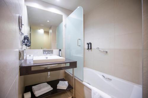 a bathroom with a sink and a tub and a mirror at Itaca Jerez by Soho Boutique in Jerez de la Frontera