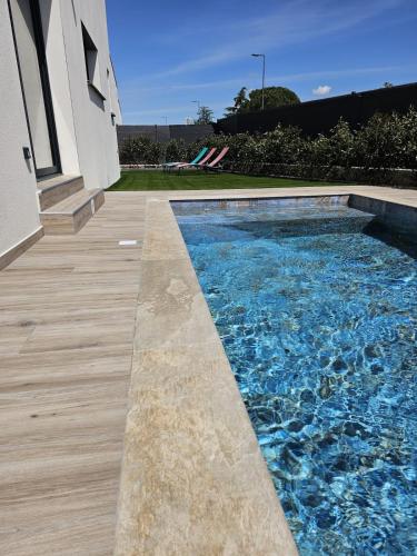 - une piscine à côté d'une maison dans l'établissement Villa neuve avec piscine, à Vauvert