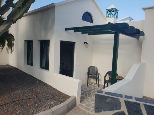 Biały dom ze stołem i krzesłem w obiekcie Ruhige Ferienwohnung Für 4 Personen w Costa Teguise