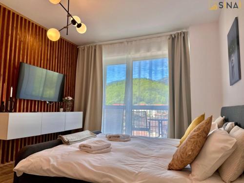 a bedroom with a large bed with a large window at SINAI APH Apartments in Sinaia