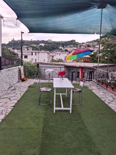 a table and chairs and an umbrella on a balcony at Aleko Guest House in Gjirokastër