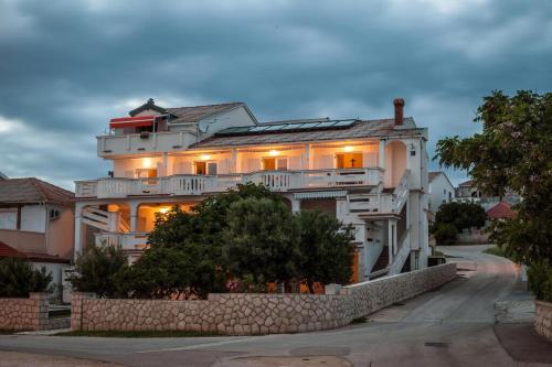 a large white building with a stone wall at Appartement Rajka in Kustići