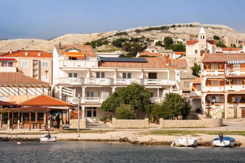 a group of buildings with boats in the water at Appartement Rajka in Kustići