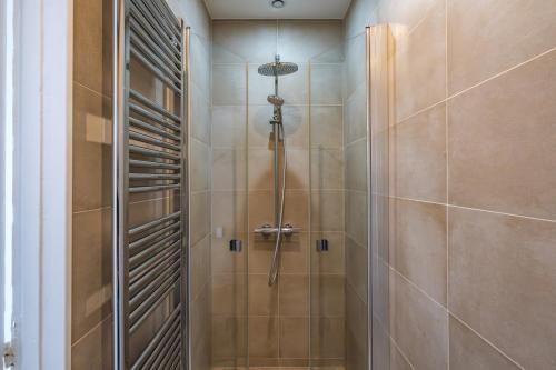 une douche avec une porte vitrée dans une salle de bain dans l'établissement Apt 4 Guests Moderne & lumineux Paris 8ᵉ, à Paris