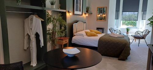 a small room with a bed and a table and a table at Crescent House in Plymouth