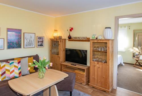 a living room with a television and a table at Ferienhaus In Alt Schadow Mit Grill Und Terrasse in Markische Heide