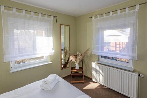 a bedroom with two windows and a bed at Ferienhaus In Alt Schadow Mit Grill Und Terrasse in Markische Heide