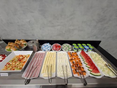 a table topped with different types of food on plates at HOTEL JD cravinhos in Cravinhos