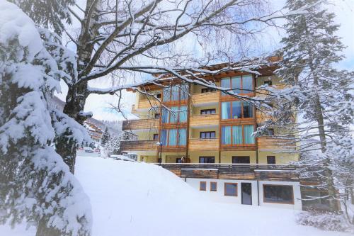 a building in the snow with snow covered trees at Ferienwohnung Design Chalet In Bad Kleinkirchheim in Bad Kleinkirchheim