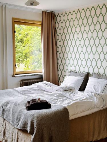 a bedroom with a white bed with a window at Bungenäs Badhotell in Fårösund