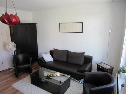 a living room with a black couch and a table at Charmante Wohnung In Malchow in Malchow