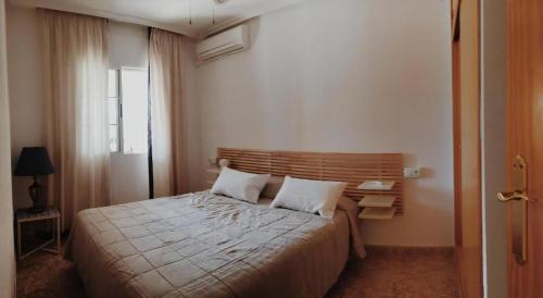 a bedroom with a large bed with two pillows at Schönes Ferienhaus Mit Pool Und Terrasse in Los Urrutias