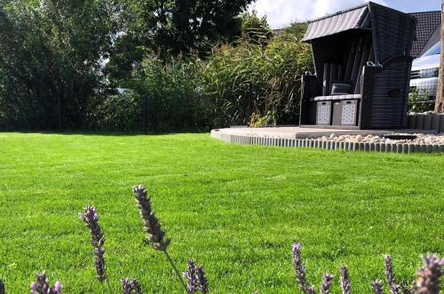a small black building in a field of green grass at Haus Am Yachthafen in Ostseebad Karlshagen