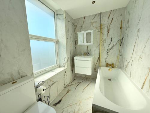 ライにあるPass the Keys The Lookout at Rye - great viewsの浴槽と洗面台のある白いバスルーム