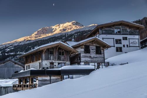 una cabaña de madera en la nieve frente a una montaña en Jagd Chalet Sölden, en Sölden