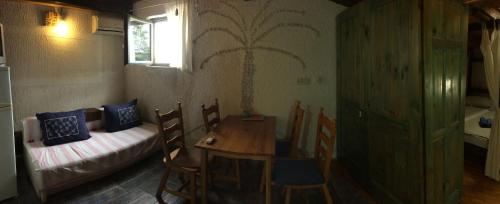 a room with a table and a bed and a table and chairs at Sommersprosse Terase in Betina