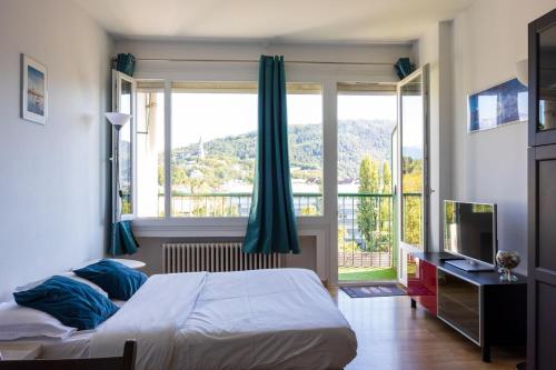 une chambre avec deux lits et une grande fenêtre dans l'établissement Panoramic Seven View, à Annecy
