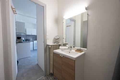 une salle de bain blanche avec un lavabo et un miroir dans l'établissement Panoramic Seven View, à Annecy