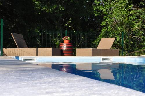 two chairs sitting next to a swimming pool at Stone House Kotli in Kotli