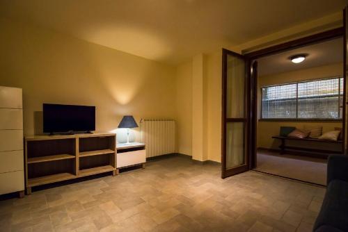 a living room with a flat screen tv and a tv stand at Quadrilocale Stella in Alberese