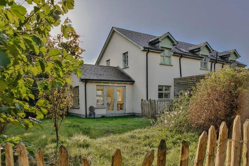 a white house with a fence in front of it at The River House in Slane