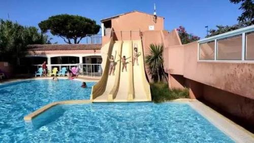 a swimming pool with people on the side of a building at Appartement 4 étoiles - Parc aquatique - ccaa0ai in Bormes-les-Mimosas