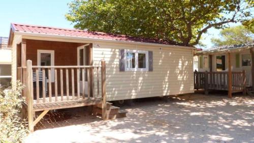 a small white tiny house with a porch at Camping 4 étoiles - eebaeh in Hyères
