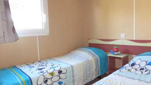 a small bedroom with two beds and a window at Camping 4 étoiles - eebaeh in Hyères