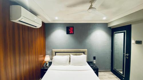 a bedroom with a bed and a tv on a wall at Gulf Hotel Mumbai- The Boutique Hotel Colaba Mumbai in Mumbai
