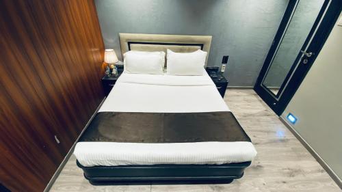 a bedroom with a bed with white sheets and pillows at Gulf Hotel Mumbai- The Boutique Hotel Colaba Mumbai in Mumbai