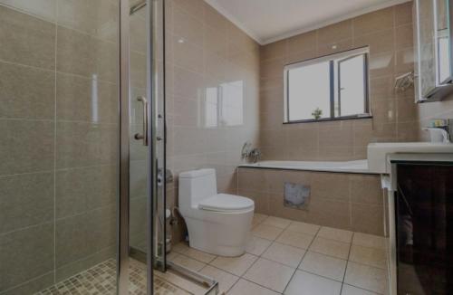 a bathroom with a toilet and a shower and a sink at La Vida Luxe in Fourways