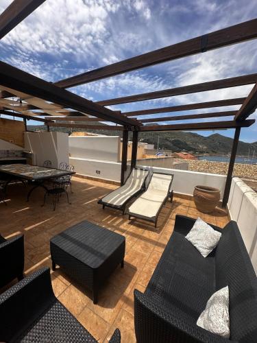 a patio with couches and a table on a roof at La Praia Favignana in Favignana